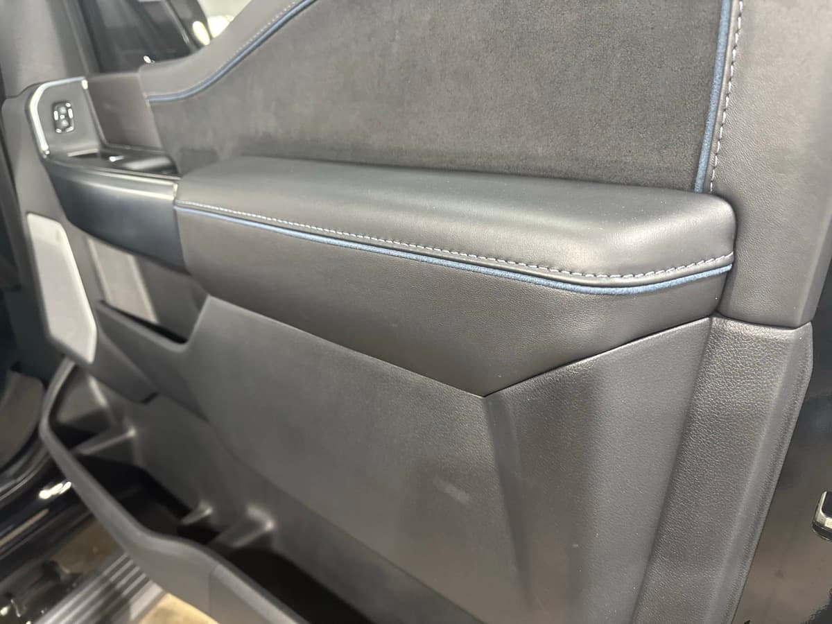 Premium gray leather door panel with white stitching after interior detail and conditioning